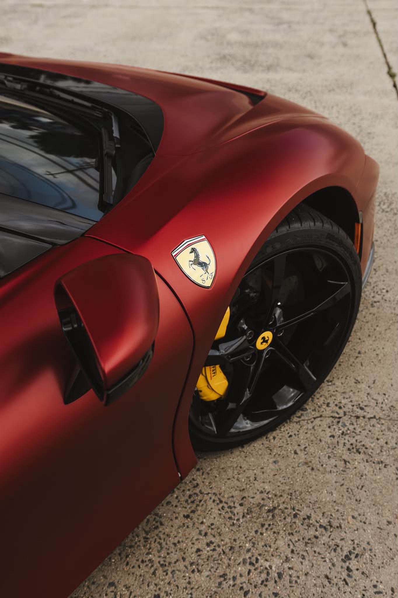 Ferrari shield, wheel, and yellow brake caliper detail